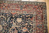 Intricate floral palmettes and sprawling arabesques in navy, ivory, and terracotta on the antique Tabriz rug.