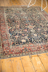 Antique Tabriz rug with intricate dark navy field, sprawling arabesques, and madder red floral border.