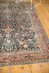 Detailed view of antique Tabriz rug's navy blue arabesque field and brick red border.