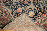Hand-knotted detail on a folded corner of the antique Tabriz rug, showing deep navy pile and woven foundation.