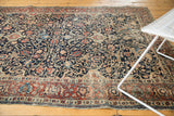 Antique Tabriz rug: intricate floral border, dark navy arabesque field, and mostly even wear.