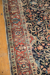 Late 19th century Tabriz rug displaying a red floral border and navy field with scrolling arabesques.