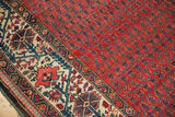 Vintage Malayer carpet's brick red boteh field transitioning to an ivory Mir Serbend border.