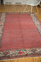 Brick red boteh field and ivory Mir Serbend border of a vintage Malayer carpet.