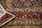 Vintage Bijar's intricate red border with arabesque blossoms, Herati motif, and secured fringe.