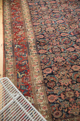 Detailed view of traditional vintage Bijar carpet's intricate red border and navy Herati field, with blush and sky blue accents.