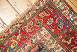 Intricate budded blossoms and floral top views on ivory border of a vintage Persian Bijar rug.