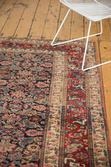 Bijar carpet's intricate border, budded blossoms, Herati motif; navy, cherry red, blush tones.
