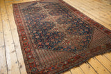Vintage Qashqai rug section with navy germinating plants, red zigzag motif, low pile.