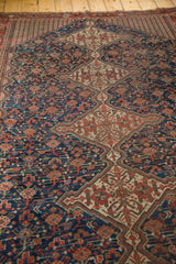 Vintage Qashqai carpet's central medallion, navy field of germinating plants, red, ivory.