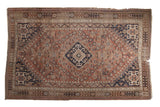Vintage Qashqai rug: diamond rams horn medallion, allover floral, chestnut, navy, rust. Mostly even wear.