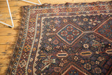 Antique Persian Kamseh rug's navy border with traditional red, sky blue, and ivory motifs, and naturally worn fringe.