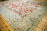 Distressed Tabriz carpet corner, with faded cherry red palmettes and powder blue vinery.