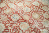 Distressed cherry red Tabriz rug with blue, beige palmette and vine motifs.