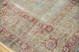 Distressed vintage Tabriz rug corner with faded slate blue Herati and wine red turtle border.