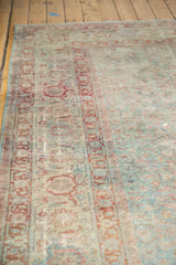 Angled view of distressed Tabriz carpet, worn Herati motif in muted blue and red.