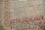 Distressed vintage Tabriz carpet revealing worn Herati motif in muted slate green and red.