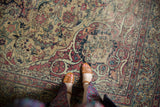 Intricate curvilinear floral patterns in antique ivory, cochineal red, and blue with mostly even wear.