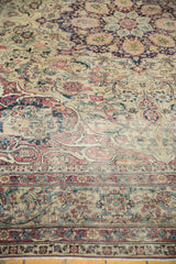 Intricate curvilinear floral design, detailed border, muted red, navy, and antique ivory tones.