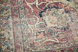 Intricate floral motifs and border of antique Persian Kermanshah rug, cochineal red and ivory.