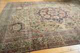 Intricate floral details and layered borders with time-softened tones on the Kermanshah carpet.