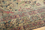 Antique Kermanshah rug showcasing intricate floral arrangements and a cochineal red border.