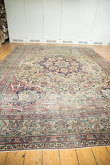 Antique Kermanshah carpet's intricate floral field, cochineal red borders, and largely even pile wear.