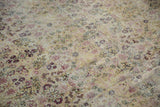 Antique Kerman carpet showcasing intricate faded floral vinery on an antique ivory ground, with soft, even pile wear.