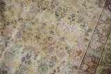 Intricate floral vinery on Antique Kerman carpet in cochineal red, ivory, and navy, with even wear.