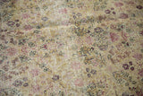 Antique Kerman carpet with faded cochineal red vinery on ivory, showing even pile wear.