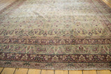 Antique Kerman carpet's intricate floral vinery border, rendered in cochineal red and ivory tones.
