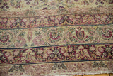 Visible knot heads and intricate cochineal red floral vinery on antique Kerman carpet's ivory field.