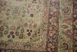 Intricate cochineal red blossomed vinery on antique ivory Kerman carpet with soft patina.