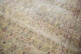Intricate allover floral vinery of an antique Kerman carpet, displaying even wear and cochineal red on ivory.