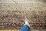 Intricate cochineal red floral border and ivory field on an antique Persian Kerman rug.