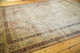 Corner of antique Kerman carpet, featuring intricate mil fleur pattern, navy border, and mostly even wear.