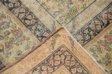 Folded corner of antique Kerman rug, revealing intricate navy, red floral motifs and woven foundation.