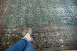 Decorative distressed Mahal carpet, featuring henna plant design, pale green, blue, and exposed foundation.