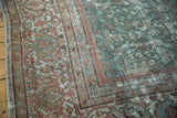 Distressed Mahal carpet's worn floral border and faded pale seafoam green field.
