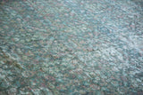 Textural Mahal carpet with distressed pile, faded blue-green tones, and visible foundation.