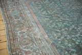 Distressed texture of a vintage Mahal carpet, showing sky blue field and cochineal floral border.