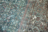 Distressed Vintage Mahal carpet section, revealing faded blue, pink floral patterns and exposed foundation.