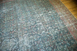 Faded blue-green henna plant design and distressed pile of a vintage Mahal rug.