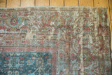 Vintage distressed Mahal carpet corner showing exposed foundation, teal and red floral patterns.