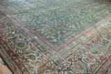 Mahal carpet corner with distressed texture, showing sky blue and cochineal floral vine motifs.