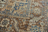 Distressed Heriz carpet pile revealing foundation and rectilinear design in brown, blue.