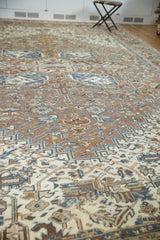 Textured distressed Heriz rug surface with soft brown, antique ivory, and denim blue motifs.
