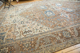 Distressed vintage Heriz rug, showing wear, rectilinear patterns, and pops of denim blue.