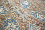 Worn texture of distressed Heriz carpet, with bronze, denim blue, and ivory motifs.