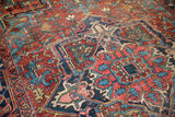 Close-up of vintage Heriz rug, geometric pattern in cherry red, navy blue, vivid aqua.